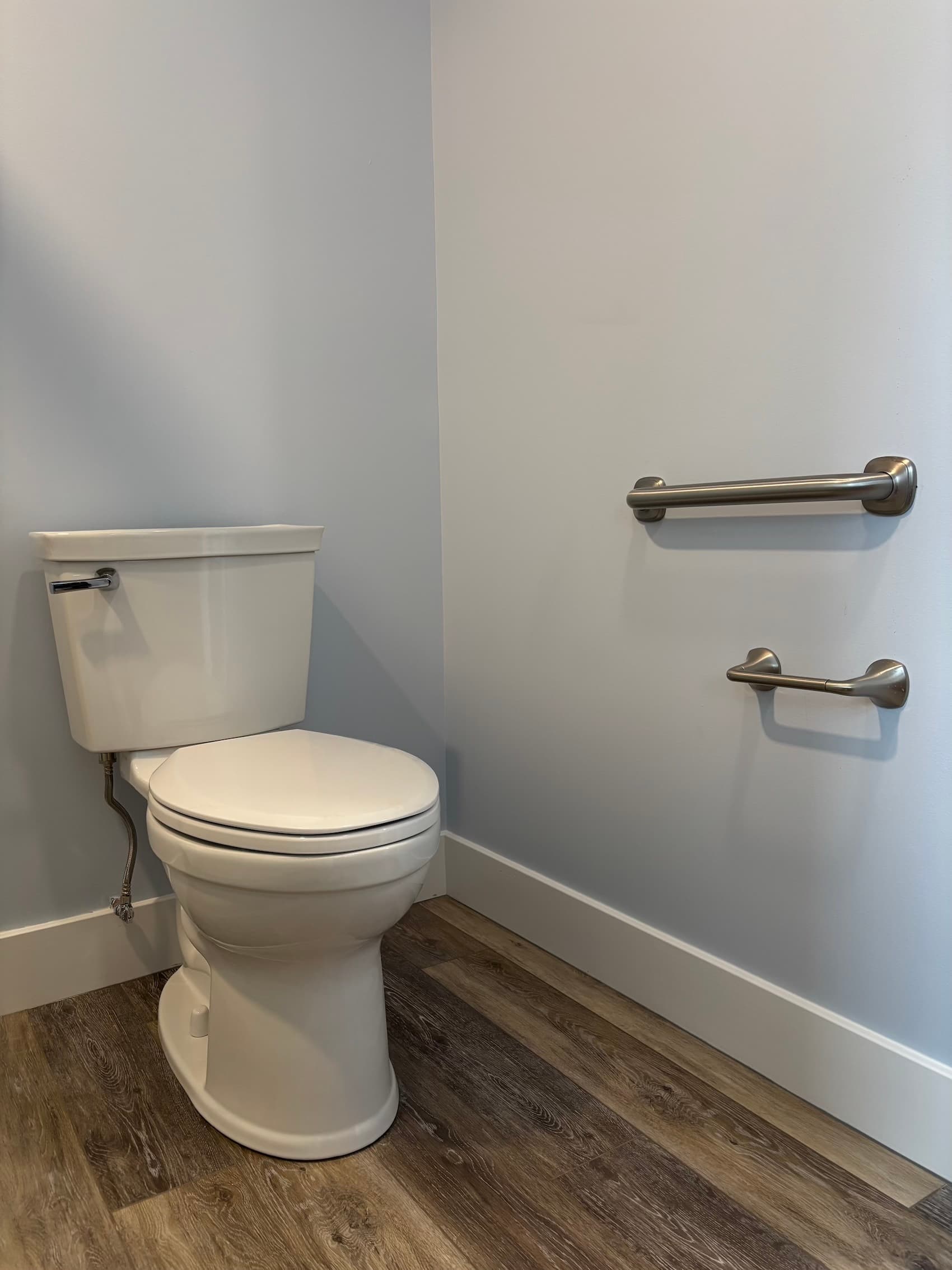 Sturdy grab bars installed beside a toilet for safe transfers.