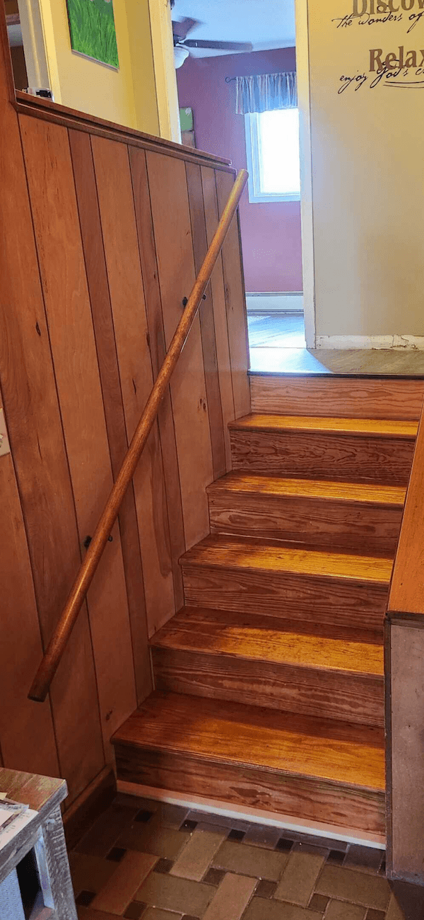 Solid wood handrail along interior stairs for added safety.